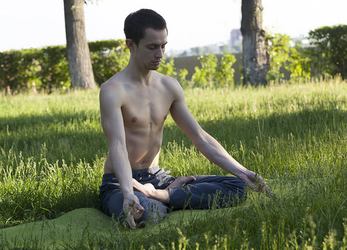  young man meditating in a lotus pose. practice of yoga. breathing exercises. practice of yoga.