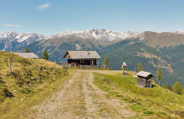 Wooden shepherd lodge with Alpine mountain landscape in Austria.