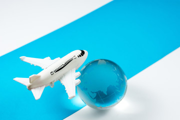Fototapeta na wymiar Airplane flying concept travel plan over the globe which show the map of earth on blue and white background, copy space