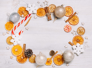 Fototapeta na wymiar Christmas frame made from oranges. cinnamon, candies, various festive decor. copy space, free space for your text. close up
