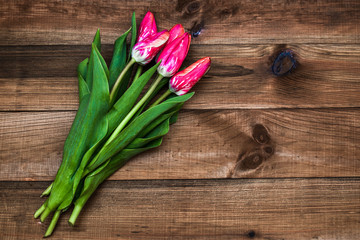 A bouquet of tulips on a wooden table, Top view with copy space.