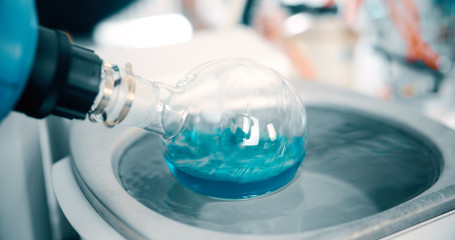 Mechanical stirring, liquid of green color is mixed in a round flask.