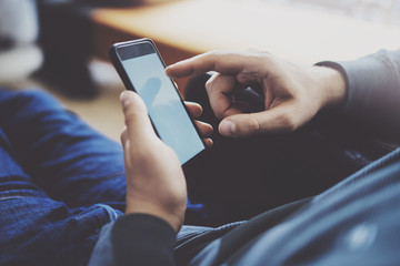 Male finger pointing to touch screen of modern smartphone . Blurred background.Blogger using mobile gadget. Horizontal.