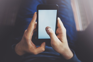 Male finger pointing to touch screen of modern smartphone . Blurred background.Blogger using mobile gadget. Horizontal.