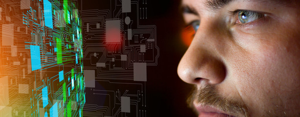 Young man in front of circuit board architecture - technology concept