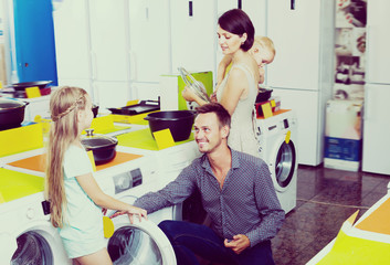 Laughing family choosing washing machine