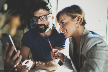 Coworkers working process at home.Young blonde woman working together with bearded colleague man at...
