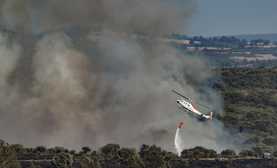 Fire in the wilderness with helicopter throwing water © F.C.G.