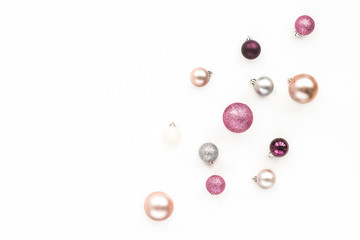 Colorful pink, purple, silver christmas balls on white background, flat lay, top view.