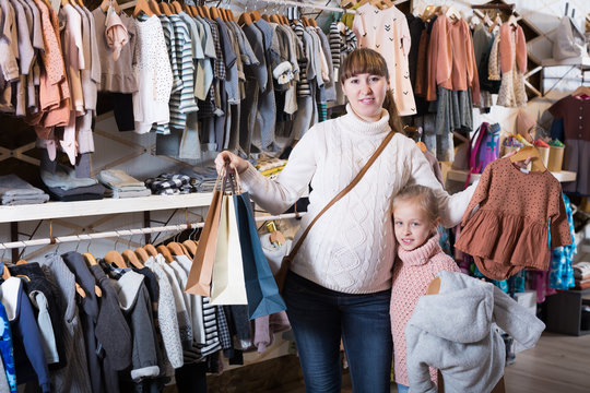 Positive pregnant mother and girl enjoying purchases