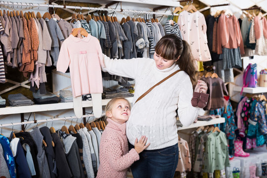 Woman and child searching clothes for newborn
