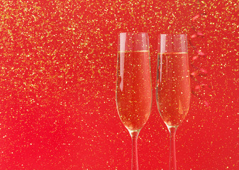 Champagne flutes on red holiday background