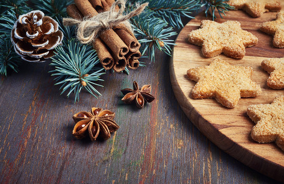 Christmas background with Christmas tree twigs, star-shaped cookies