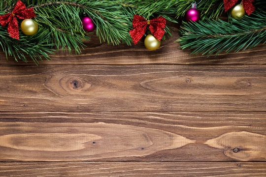 Nice christmas theme on the wooden background with pine tree branches on the top of the screen