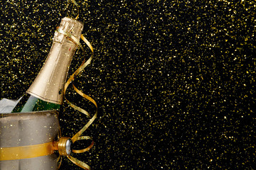 Decorated bottle of champagne in a bucket on dark backgroud. Copy space