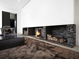 Modern livingroom with large fireplace with black furniture