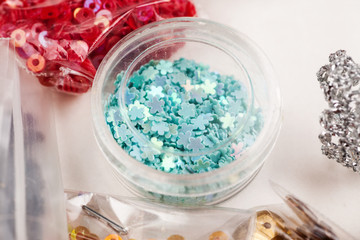 Different colour beads for handcraft and beading in plastic packages on a white background