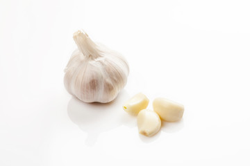 Fresh peeled and unpeeled garlic on a white background