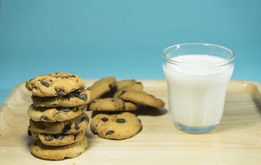 MILK GLASS AND CRACKERS A glass of milk with pile of crackers on the wood top table.