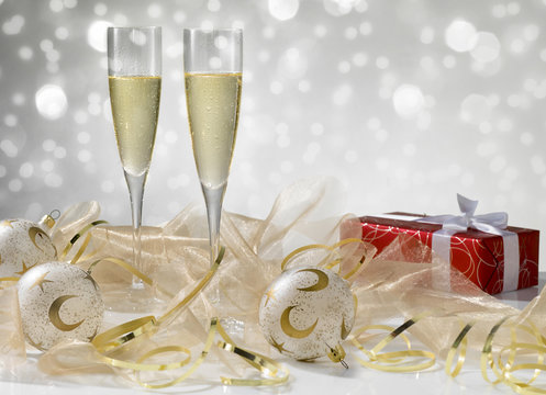 Two champagne glasses, golden decoration. Red gift with white ribbon, stylish tinted