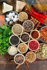 Variety of different asian and middle east spices, colorful assortment, on old wooden table