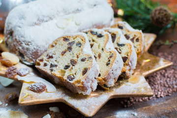 Traditional German Christmas raisins and dried fruits cake with sugar powder and Christmas decorations