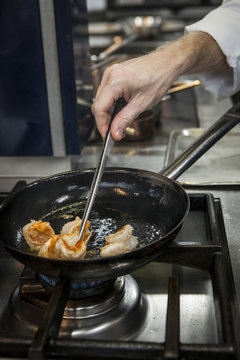 Chef Cook preparing seafood on a stove