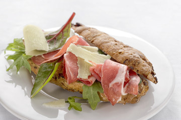  Close-up of tasty rye bread sandwiches with roast meat and vegetables, on a white background