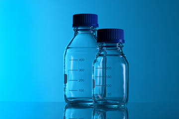  Labotatory test glass container on a blue background