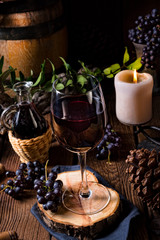 Red wine from a barrel with grapes and a glass of wine