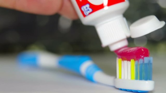 Red toothpaste on a toothbrush