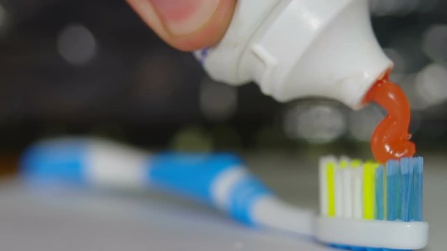 Orange toothpaste on a toothbrush