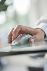 male hand clicking a cordless computer mouse on a green table