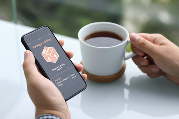 men hands holding phone with app tracking delivery package screen