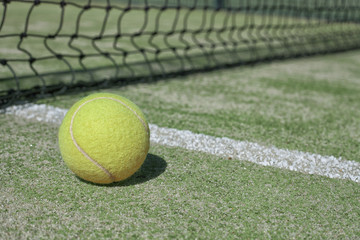 Tennis ball on a tennis court next to the side line