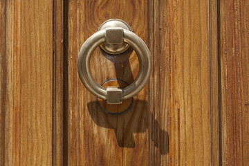 Vintage image of ancient door knocker on a wood