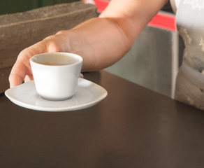 Waitress holding espresso, ready to serve