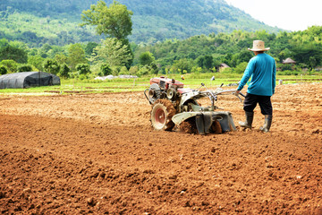 Farmer plowing the field. Cultivating tractor in the field