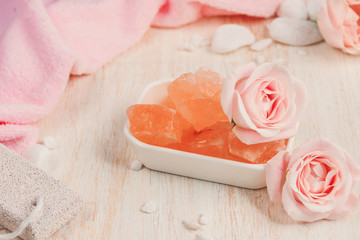 Spa settings with roses. Various items used in spa treatments on white wooden background.