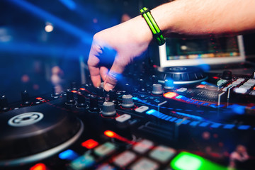 Fototapeta na wymiar professional panel DJ mixer with hand controlling mixing music in nightclub