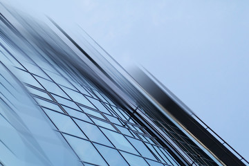 Fototapeta premium Abstract business modern city urban futuristic architecture background. Real estate concept, motion blur, reflection in glass of high rise skyscraper facade, toned blue picture with bokeh