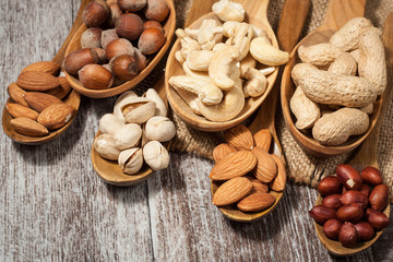 Healthy mix nuts on wooden background. Almonds, hazelnuts, cashews, peanuts, pistachios, brazilian nuts