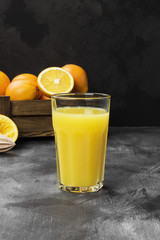 Oranges and fresh orange juice on a black background