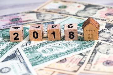 2018 new year cubes with the house model on group of cash, the business finance and property concept