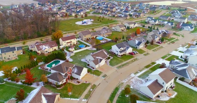 Beautiful neighborhoods, homes with white glazed rooftops after first snow, aerial view.