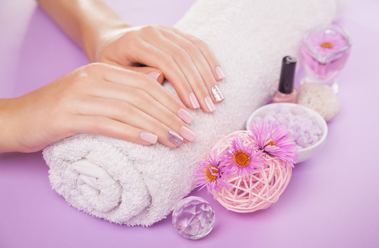 Beautiful pink and silver manicure with flowers and spa essentials