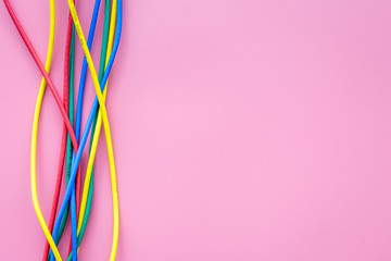 Network colored cables for computer on pink background top view copyspace