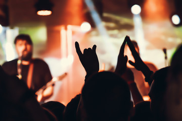 Concert Crowd. Silhouettes young people in front of bright stage lights. Band of rock stars