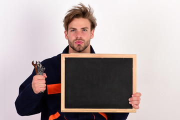 Man with beard and serious face holds chalkboard