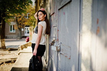 Naklejka premium Stylish brunette girl wear on leather jacket and shorts posing at street.